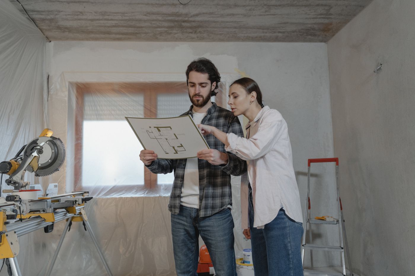 Handwerker bespricht gemeinsam mit einer Kundin den Projektplan